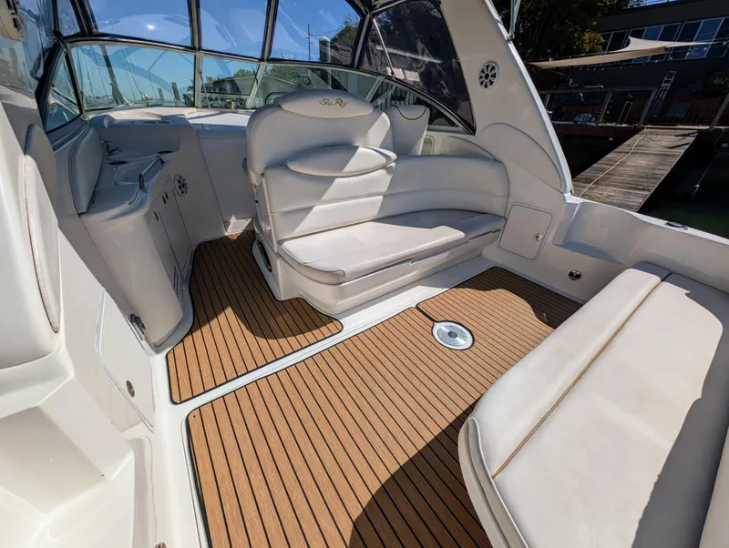 Slide: The Image of Interior of 2000 Sea Ray 340 Sundancer boat with white seating and wooden flooring. - 5