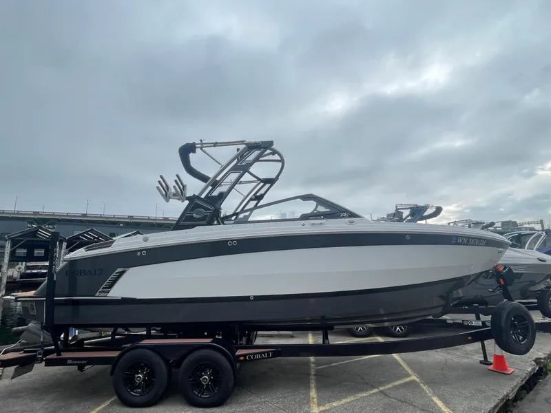 Slide: The Image of 2023 Cobalt R6 Surf boat on trailer under cloudy sky. - 1