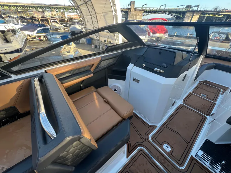 Slide: The Image of 2023 Cobalt R6 Surf boat interior with brown seating and sleek dashboard design. - 11