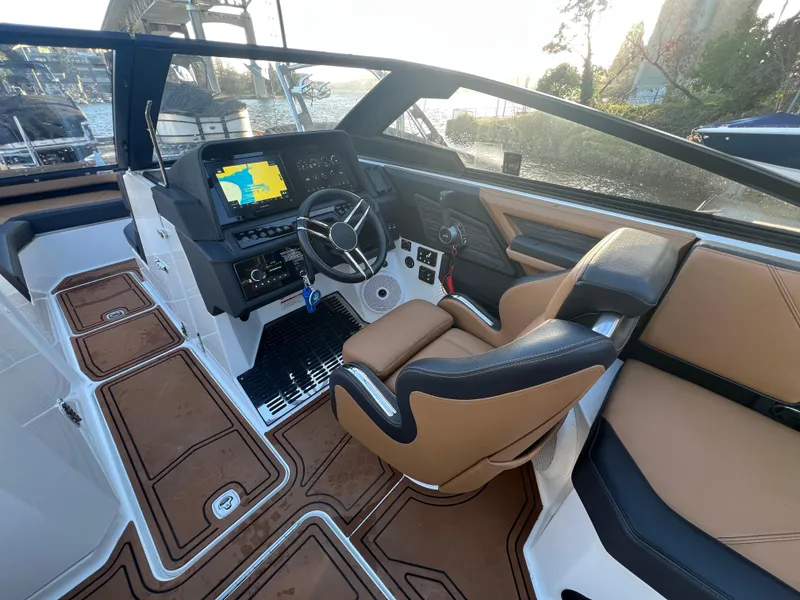 Slide: The Image of 2023 Cobalt R6 Surf boat interior with modern dashboard and tan seating. - 9