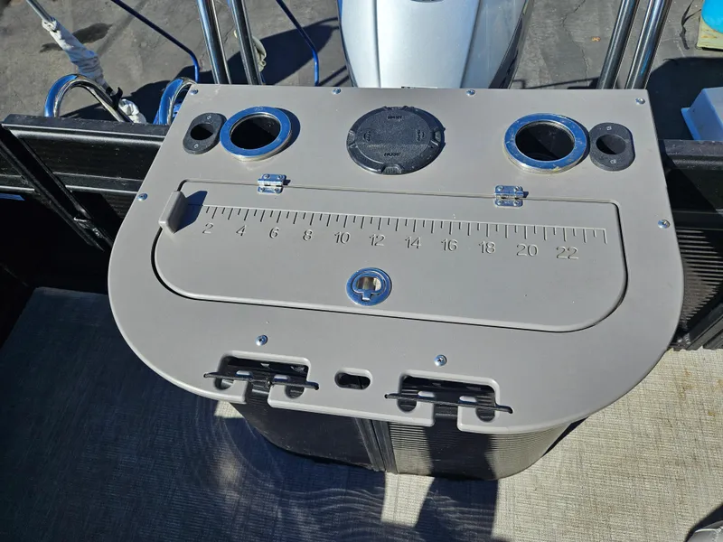 Slide: The Image of 2022 Apex Marine Qwest E CLASS 822 XRE TRITUNE boat console with cup holders and measuring scale. - 7