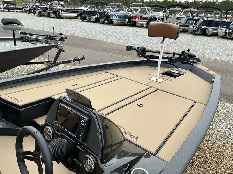 Slide: The Image of 2025 Xpress Hyper-Lift Bass Series boat with advanced dashboard and seating, parked in a marina. - 7