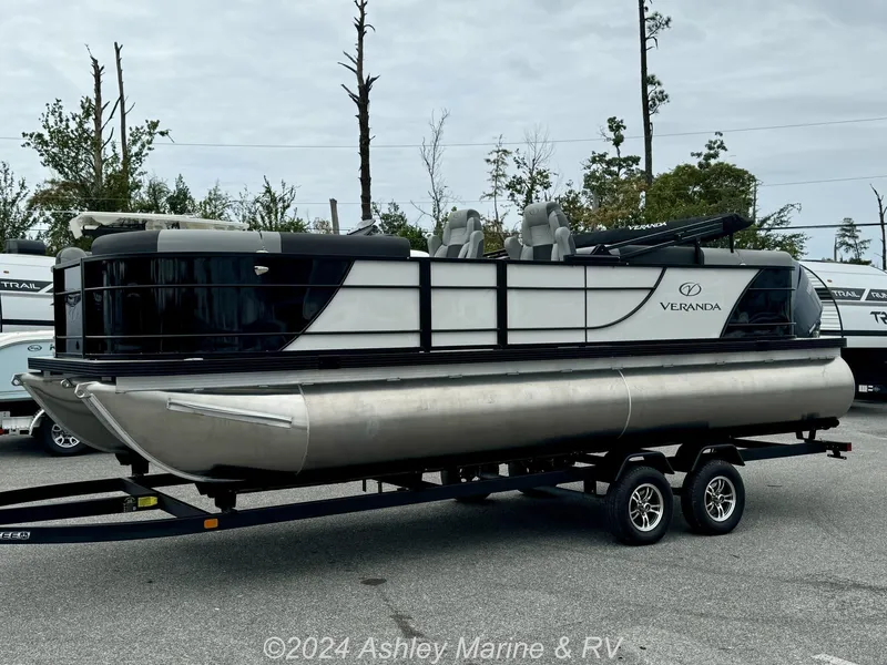 Slide: The Image of 2025 Veranda Relax Series 22RC pontoon boat on trailer, parked outdoors. - 4