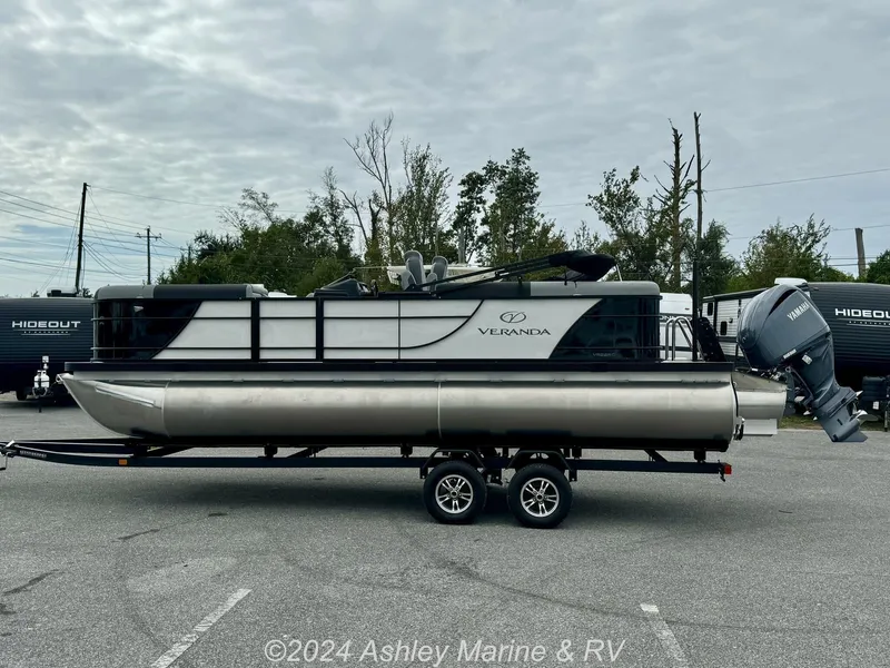 Slide: The Image of 2025 Veranda Relax Series 22RC pontoon boat on trailer, parked outdoors. - 3