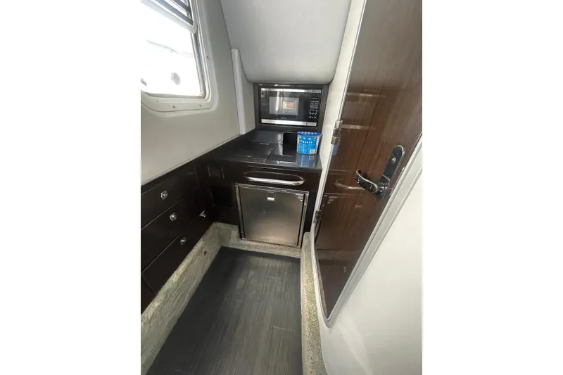 Slide: The Image of 2017 Formula 350 Crossover Bowrider OB cabin with kitchenette, microwave, and mini-fridge. - 15