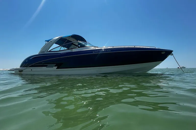 Slide: The Image of 2017 Formula 350 Crossover Bowrider OB on calm water under clear blue sky. - 2