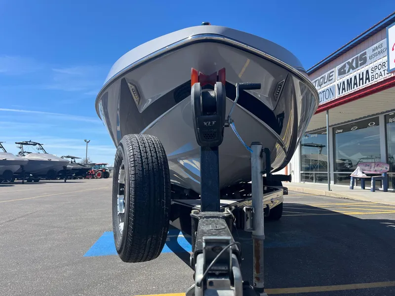 Slide: The Image of 2017 Axis Boats T22 on trailer outside dealership under clear blue sky. - 12
