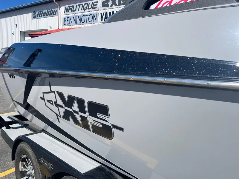 Slide: The Image of 2017 Axis Boats T22 on trailer, parked outside dealership with brand signage. - 15