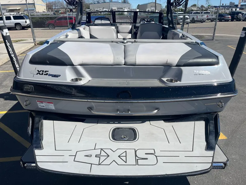 Slide: The Image of 2017 Axis Boats T22 rear view in a parking lot, showcasing seating and swim platform. - 7