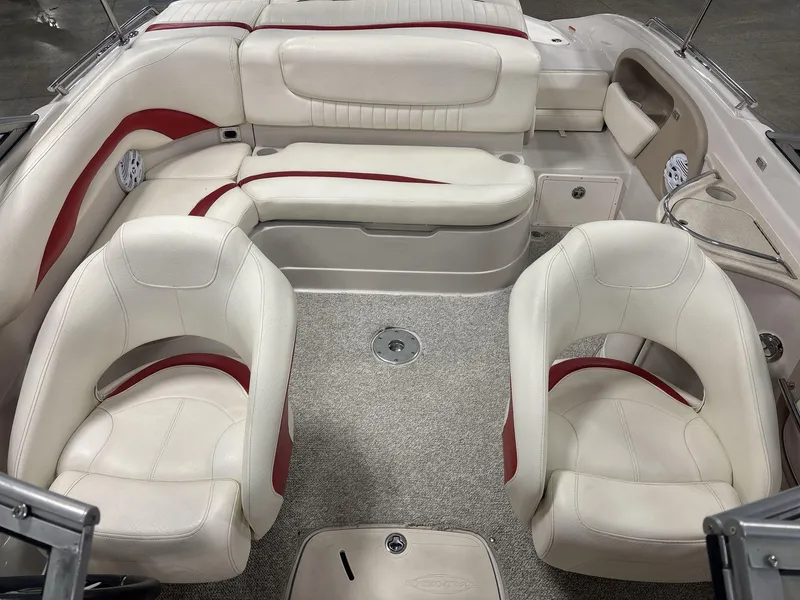 Slide: The Image of 2007 Tahoe Q8i boat interior with white and red seating, carpeted floor, and cup holders. - 8