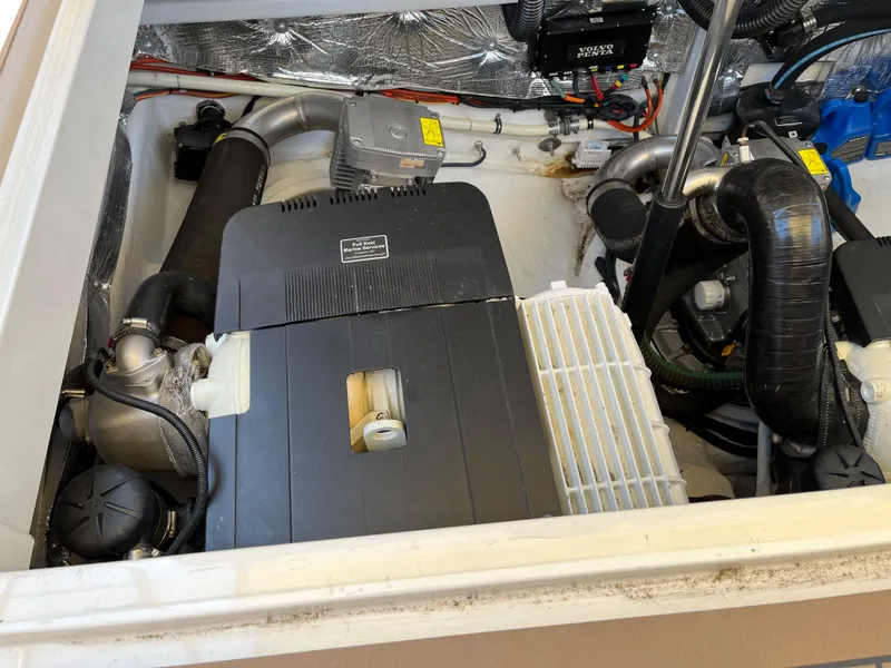 Slide: The Image of Engine compartment of a 2016 MJM 50z boat, showcasing mechanical components and wiring. - 24