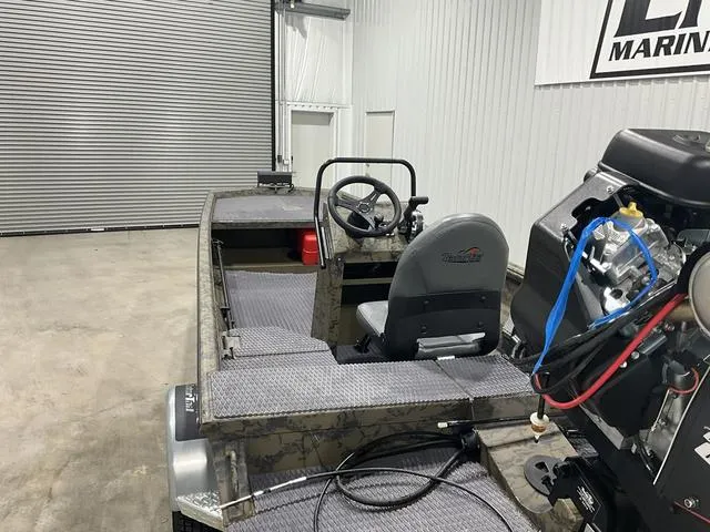 Slide: The Image of 2025 Gator Tail 1860 Extreme series boat in a garage, featuring a steering console and motor. - 4