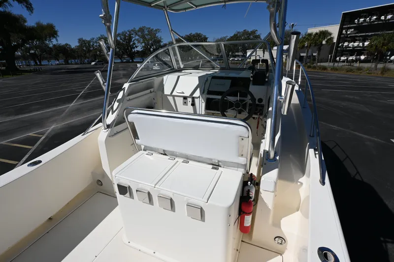 Slide: The Image of 1998 World Cat 266 SC boat interior with steering wheel and seating in a parking lot. - 13