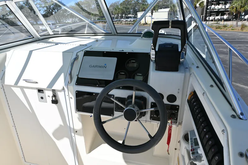 Slide: The Image of 1998 World Cat 266 SC boat helm with Garmin navigation system and steering wheel. - 8