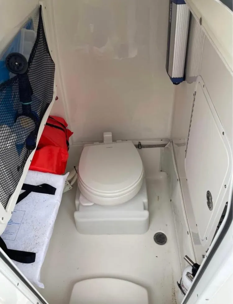 Slide: The Image of 2018 Sea Hunt Gamefish 25 boat interior with toilet and storage compartments. - 17