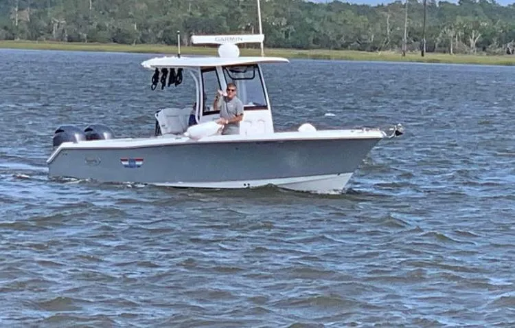 Slide: The Image of 2018 Sea Hunt Gamefish 25 boat cruising on a calm lake with a person onboard. - 4
