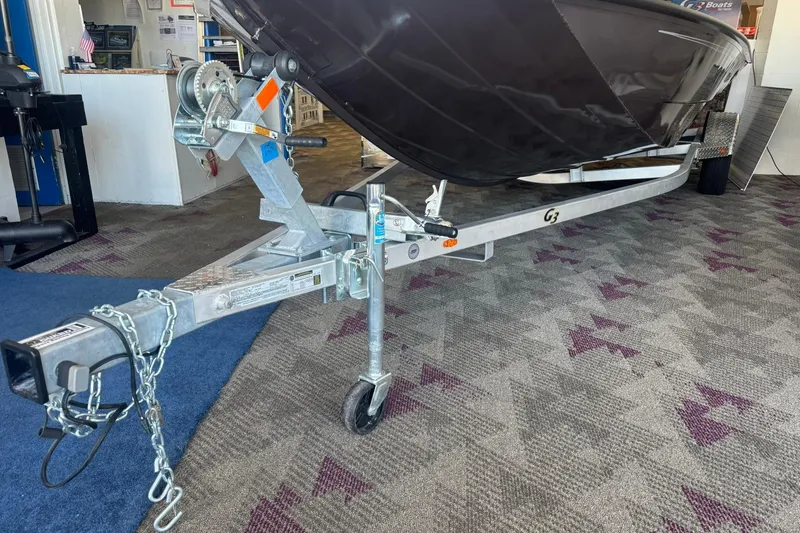 Slide: The Image of 2025 G3 Bay 19 GX boat trailer in showroom, featuring sturdy construction and secure hitch. - 15