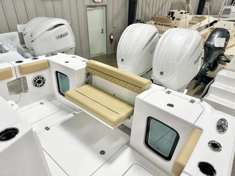 Slide: The Image of 2025 Sportsman Open 282 Center Console boat with Yamaha engines, featuring beige seating and storage compartments. - 15