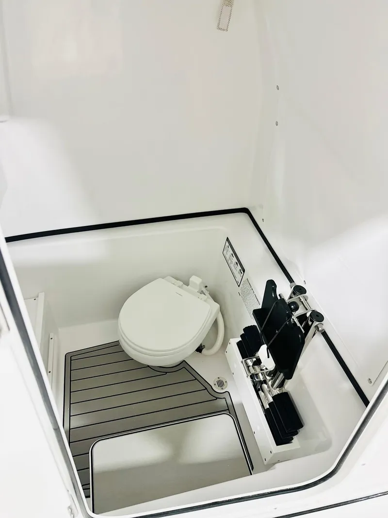 Slide: The Image of 2025 Sportsman Open 282 Center Console boat interior with toilet and storage space. - 7