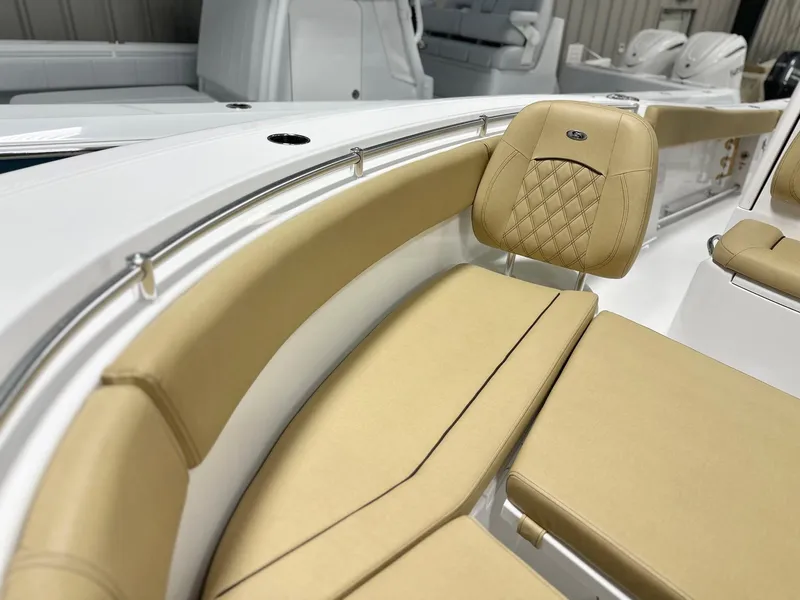 Slide: The Image of 2025 Sportsman Open 282 Center Console boat with tan cushioned seating and stainless steel railings. - 9