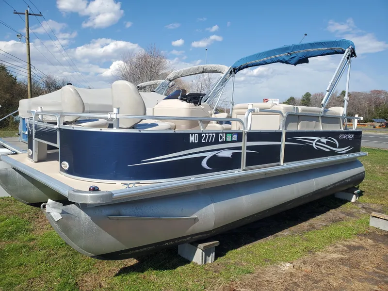 The Image of 2012 Starcraft Stardeck 206 4PT pontoon boat with blue canopy on grassy area. - 0