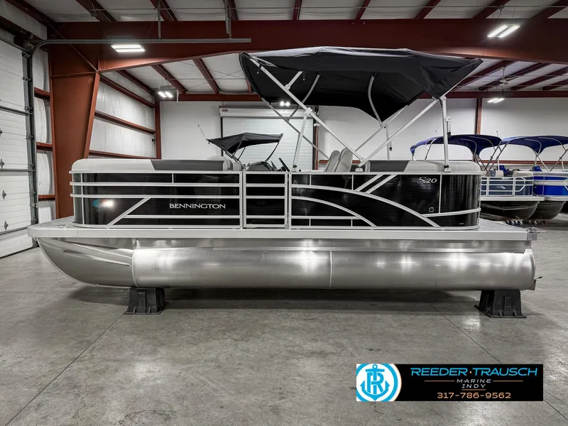 Slide: The Image of 2025 Bennington 20 SSR pontoon boat in showroom, featuring sleek design and canopy. - 11