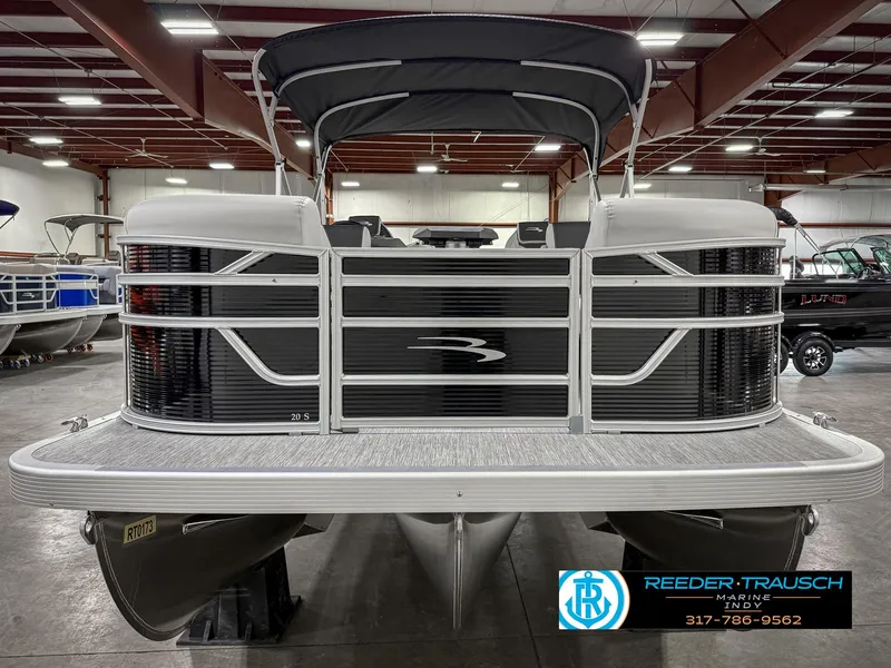 Slide: The Image of 2025 Bennington 20 SSR pontoon boat in showroom, front view, with canopy and sleek design. - 5