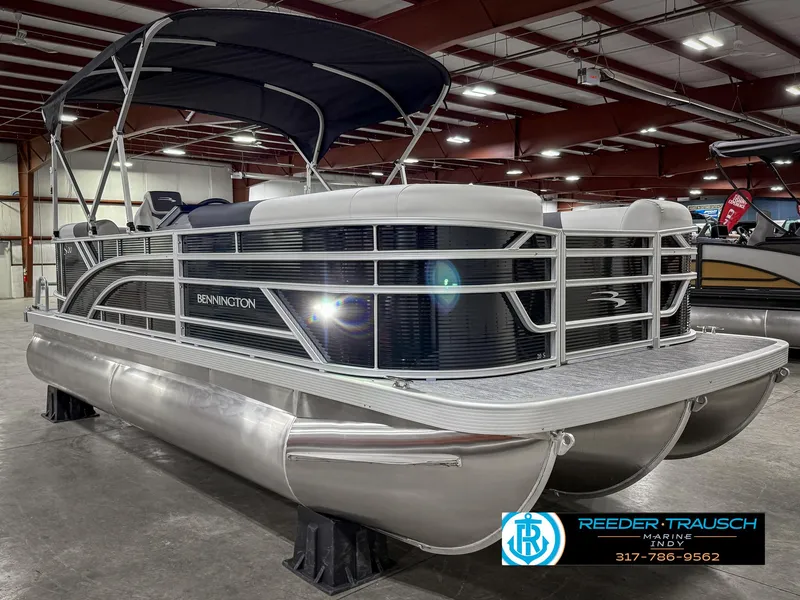 Slide: The Image of 2025 Bennington 20 SSR pontoon boat in showroom, featuring sleek design and canopy. - 6