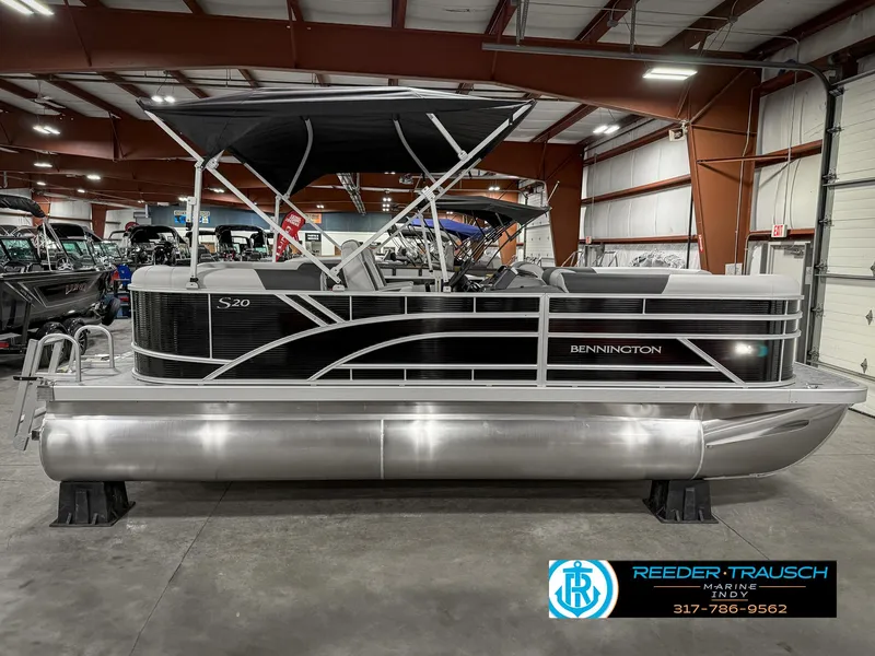 Slide: The Image of 2025 Bennington 20 SSR pontoon boat in showroom, featuring sleek black and silver design. - 7