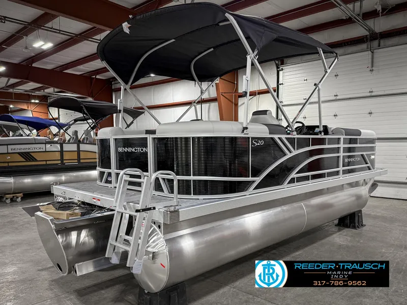 Slide: The Image of 2025 Bennington 20 SSR pontoon boat in showroom with canopy and ladder. - 8