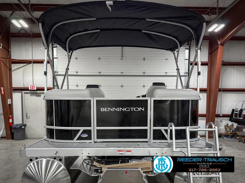 Slide: The Image of 2025 Bennington 20 SSR pontoon boat in showroom with canopy and logo. - 9