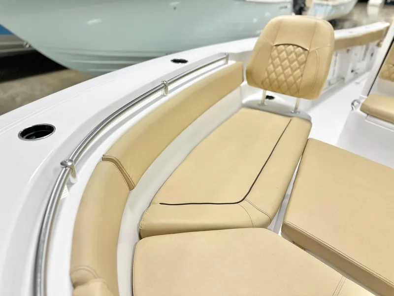 Slide: The Image of 2025 Sportsman Heritage 261 boat interior with beige cushioned seating and stainless steel rail. - 10