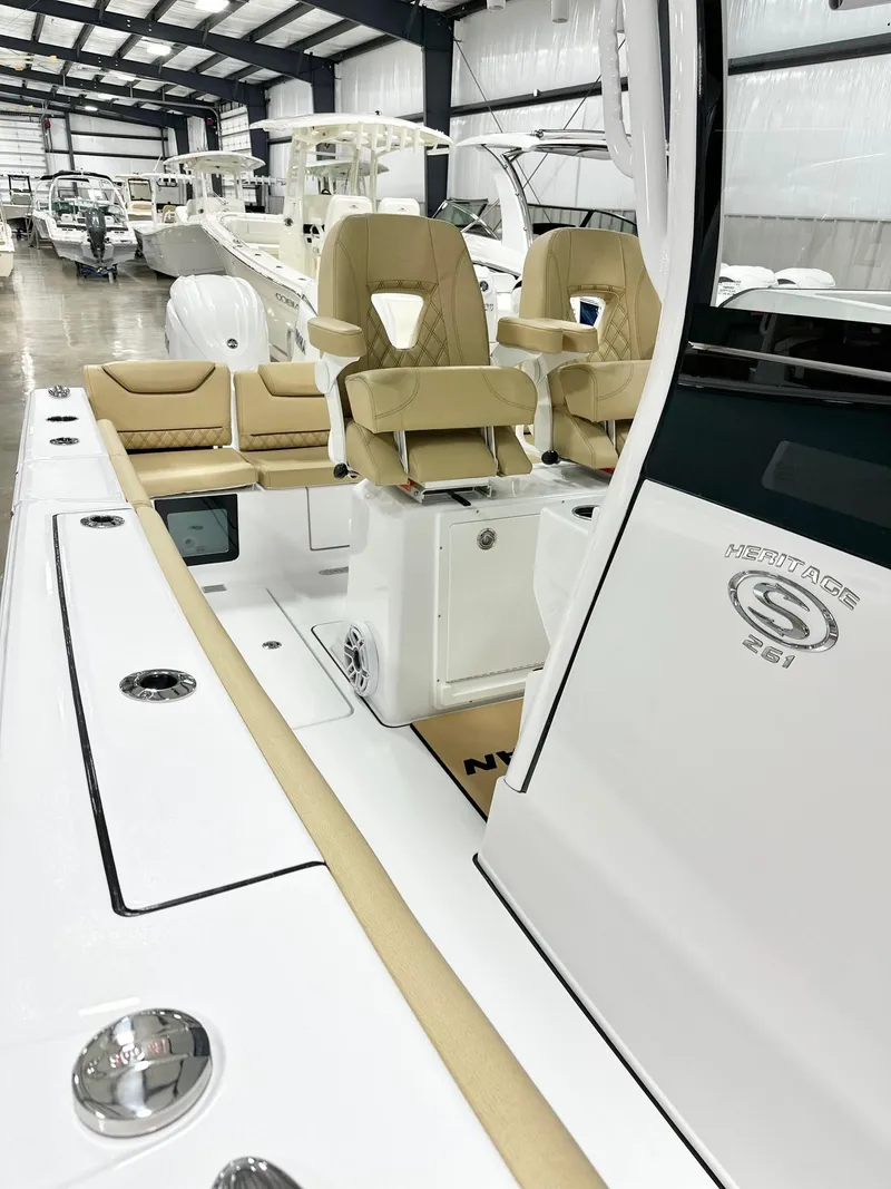 Slide: The Image of 2025 Sportsman Heritage 261 boat interior with tan seating in a showroom. - 14