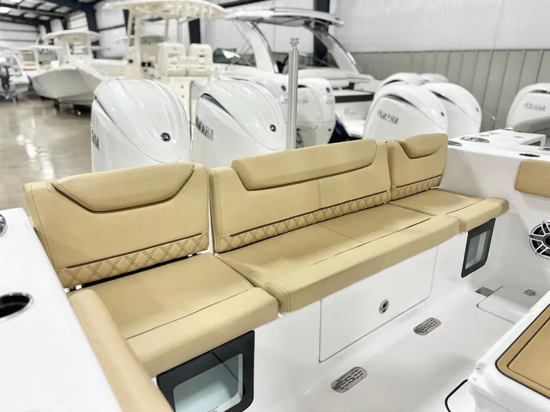 Slide: The Image of 2025 Sportsman Heritage 261 boat interior with tan seating and Yamaha engines in showroom. - 15