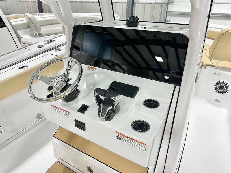 Slide: The Image of 2025 Sportsman Heritage 261 boat dashboard with steering wheel and controls. - 2