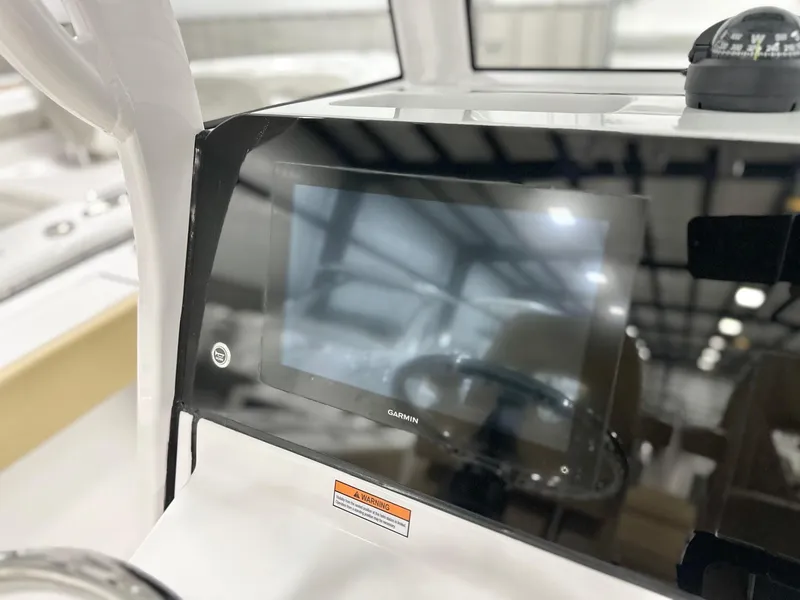 Slide: The Image of 2025 Sportsman Heritage 261 boat dashboard with Garmin display and compass. - 3