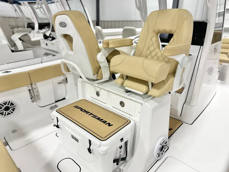 Slide: The Image of 2025 Sportsman Heritage 261 boat interior with beige seating and branded cooler. - 6