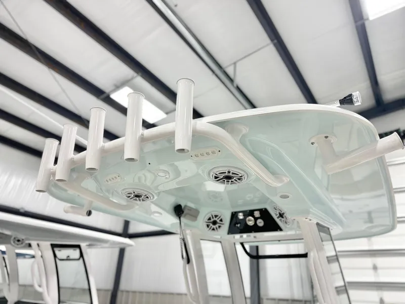 Slide: The Image of 2025 Sportsman Heritage 261 boat with rod holders and speakers in a showroom. - 7