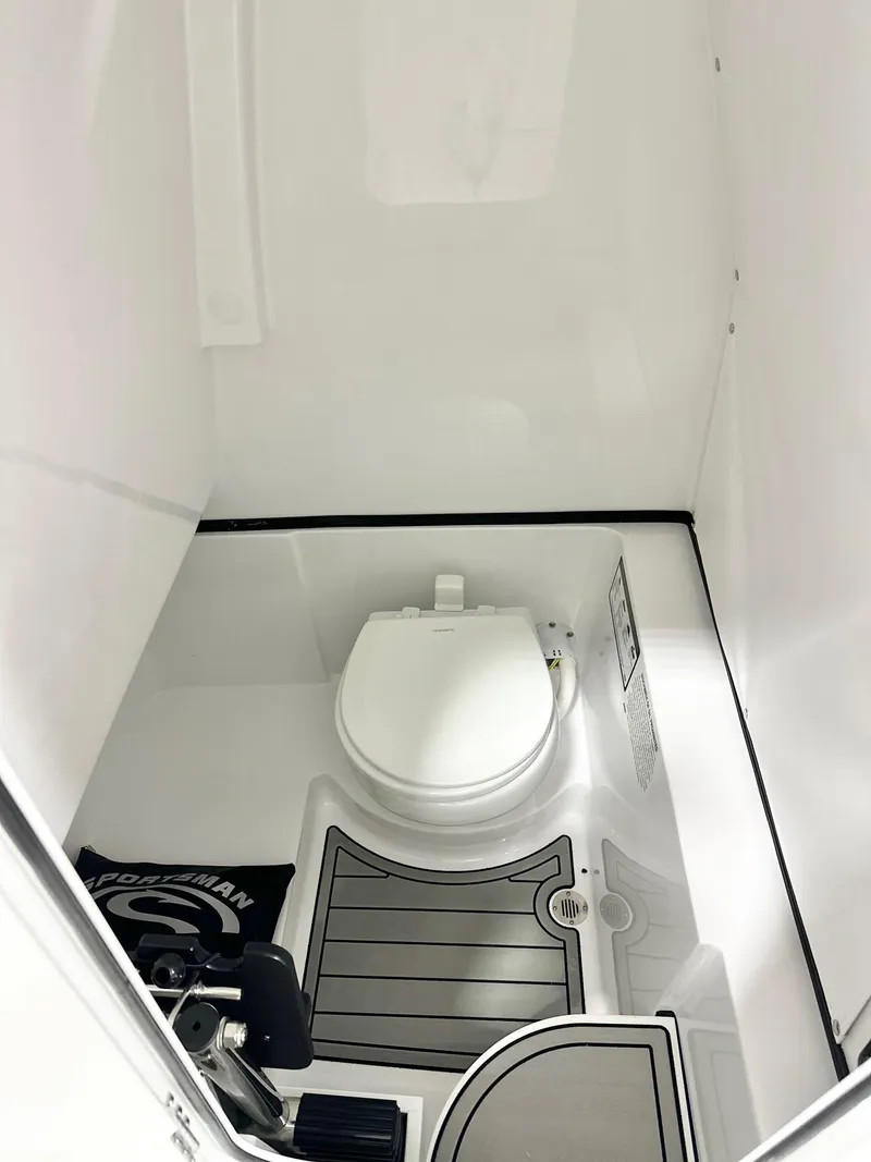 Slide: The Image of 2025 Sportsman Heritage 261 boat interior with compact marine toilet. - 8