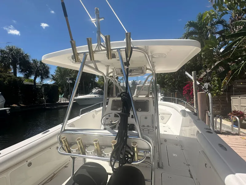 Slide: The Image of 2005 Century 3200 Center Console boat docked near palm trees under a clear blue sky. - 10
