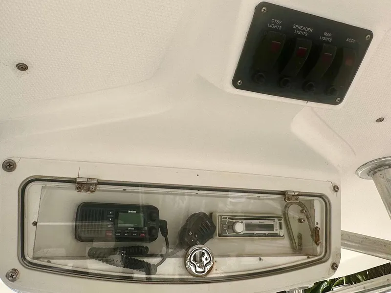 Slide: The Image of 2005 Century 3200 Center Console boat dashboard with radio and control switches. - 14