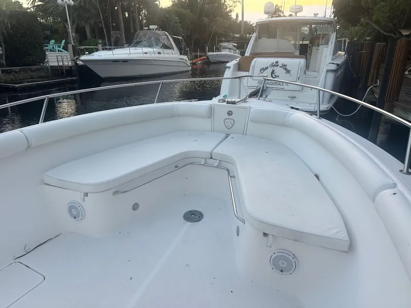 Slide: The Image of 2005 Century 3200 Center Console boat with spacious seating, docked near other vessels. - 18