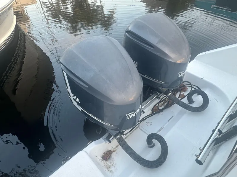 Slide: The Image of Twin outboard motors on a 2005 Century 3200 Center Console boat, docked on calm water. - 22