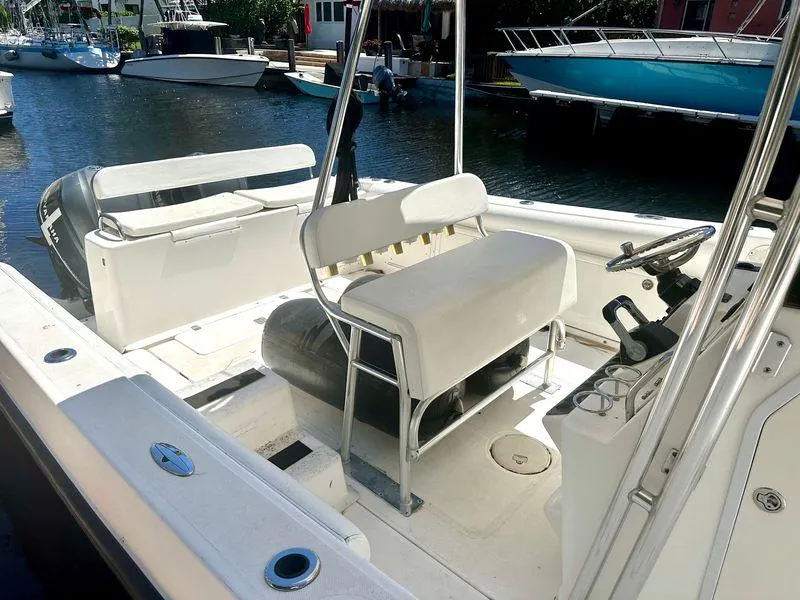 Slide: The Image of 2005 Century 3200 Center Console boat interior with seating and steering wheel, docked by the water. - 4