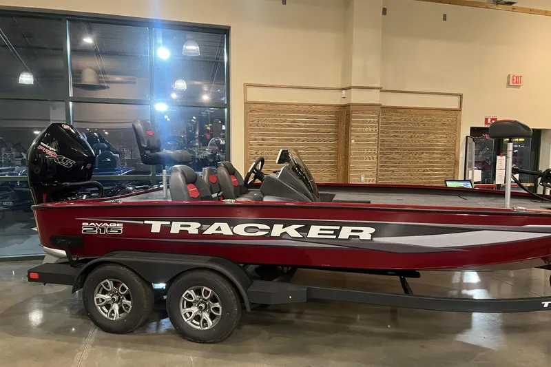 The Image of 2025 Tracker Savage 215 boat displayed indoors, featuring a sleek red design and modern seating. - 0