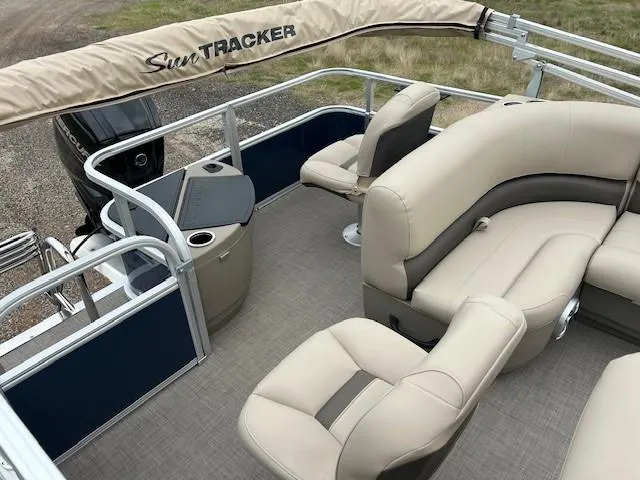 Slide: The Image of 2025 Sun Tracker Bass Buggy 18 DLX pontoon boat interior with beige seating and console. - 13