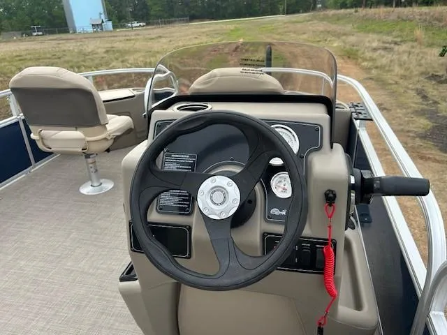 Slide: The Image of 2025 Sun Tracker Bass Buggy 18 DLX pontoon boat interior with steering wheel and seating. - 15