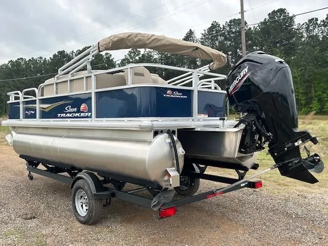 Slide: The Image of 2025 Sun Tracker Bass Buggy 18 DLX pontoon boat with Mercury outboard motor on trailer. - 3