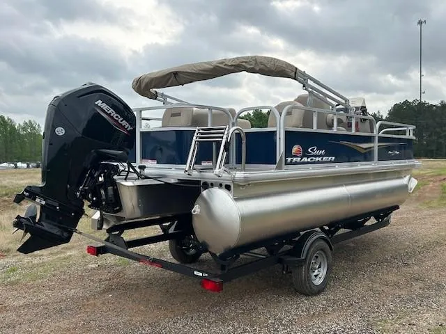Slide: The Image of 2025 Sun Tracker Bass Buggy 18 DLX pontoon boat with Mercury outboard motor on a trailer. - 5