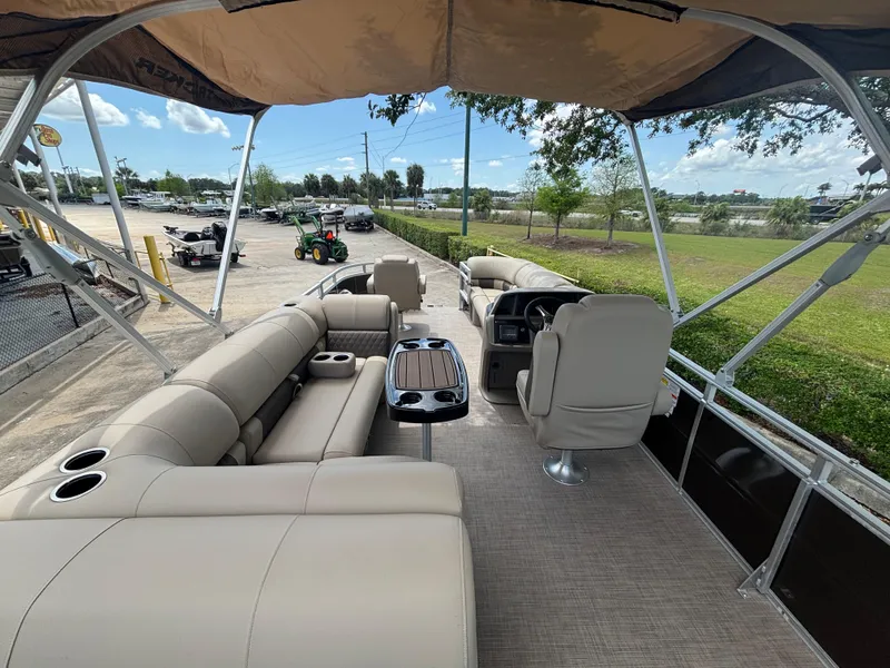 Slide: The Image of 2025 Sun Tracker SportFish 20 DLX pontoon boat interior with beige seating and canopy. - 2